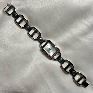 Silver tone buckle watch with black leather style grommets